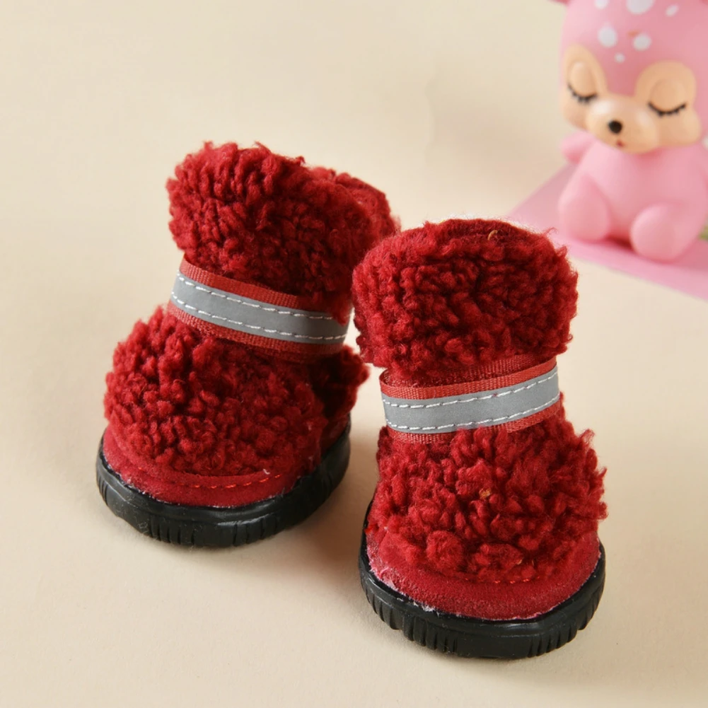 Un par de botas rojas mullidas con una raya gris alrededor de la parte superior. Parecen estar diseñados para niños, dado su tamaño y su estilo lúdico.