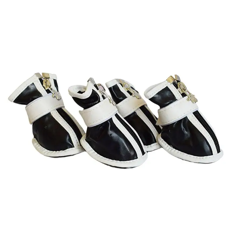 Un par de zapatos blancos y negros. Parecen ser un estilo de zapatillas con un diseño de caña alta, con correas blancas y hebillas para sujetar. Los zapatos tienen un acabado brillante, lo que sugiere que podrían estar hechos de un material como cuero o un material sintético similar al cuero.