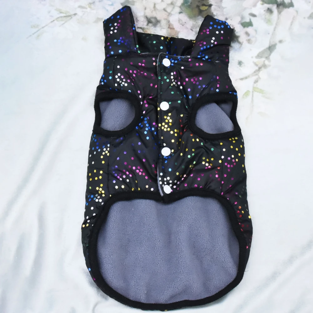 Prenda de vestir que parece un mono o un body, diseñada para un bebé o un niño pequeño. Tiene un fondo negro con un estampado de lunares de colores.