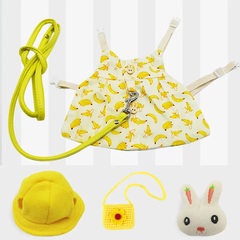 Una colección de artículos que parecen ser accesorios o juguetes para niños. Hay un sombrero amarillo con ala ancha, un bolso amarillo con estampado de plátanos, una pequeña bolsa amarilla con diseño de flores y un peluche que parece un conejito con una zanahoria.