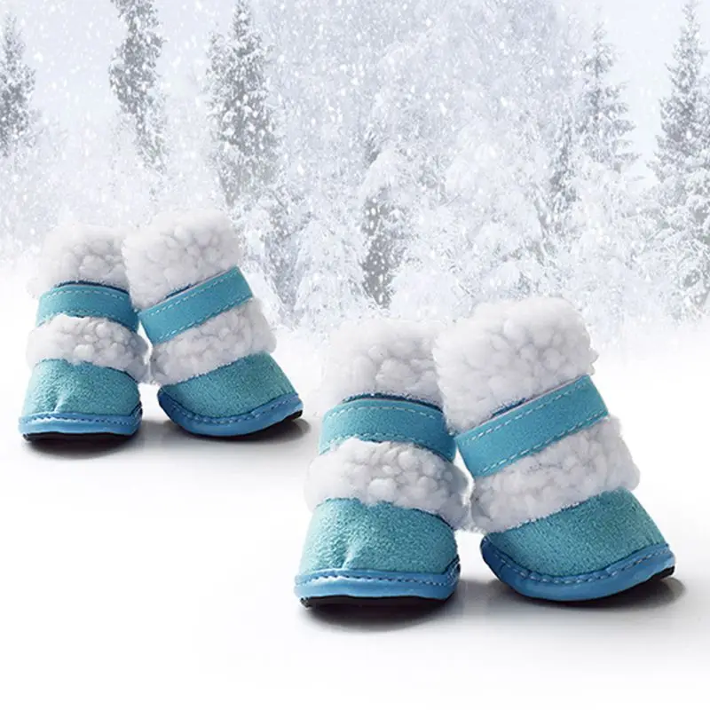 Un par de botas de nieve para niños. Tienen un color base azul con forro de piel blanca y un ribete de piel blanca alrededor de la parte superior. Las botas parecen estar diseñadas para climas fríos y condiciones de nieve, con una suela resistente que sugiere que están diseñadas para caminar sobre la nieve.