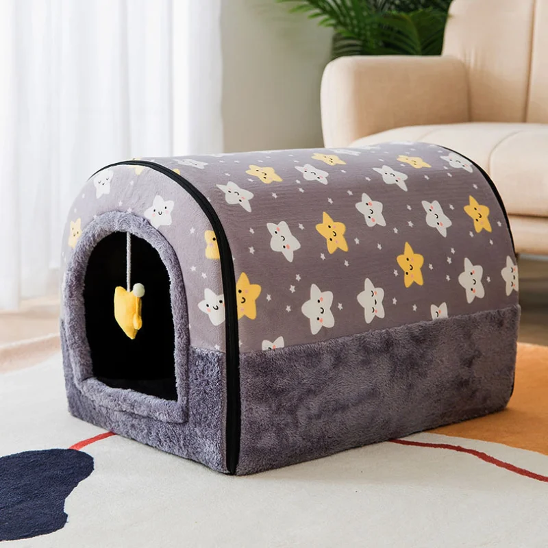 Una cama para mascotas diseñada para gatos. Tiene forma curva con una pequeña entrada y un interior acogedor. El exterior está cubierto con una tela que tiene un patrón de lindas caras de animales y estrellas, dándole una apariencia divertida y acogedora.