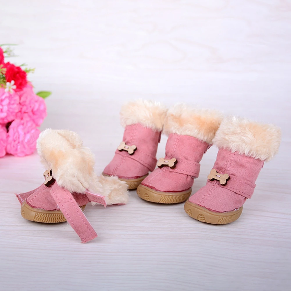 Un par de botas infantiles de color rosa con textura tipo pelo en la parte superior. Las botas tienen un detalle de lazo en el costado y parecen estar diseñadas para niños pequeños, posiblemente niños pequeños o preescolares.