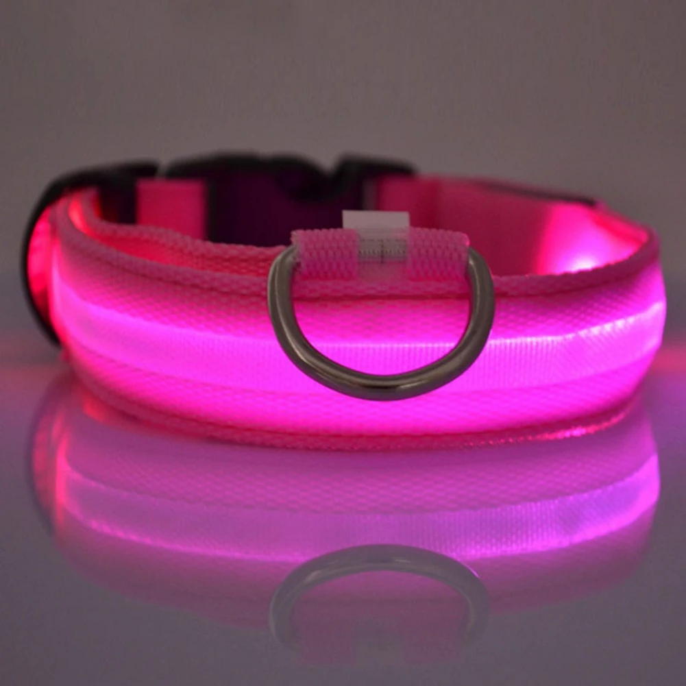 Una tira de luz LED rosa con un diseño flexible, que se utiliza a menudo con fines de iluminación decorativa. La tira está colocada sobre una superficie reflectante y tiene un anillo de metal adherido, posiblemente para montar o asegurar la tira de luz a una superficie.