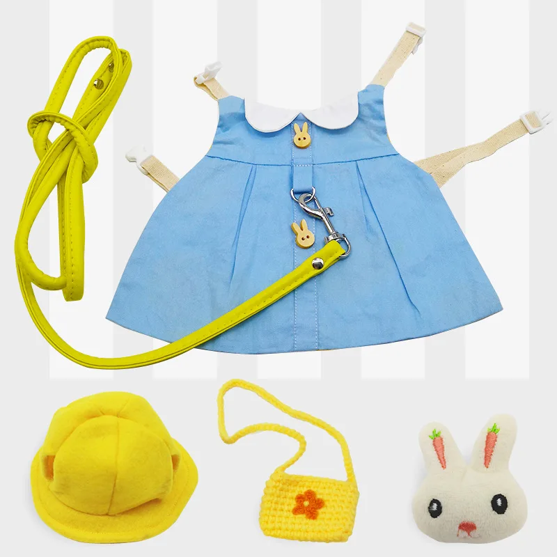 Una colección de artículos que parecen ser parte del conjunto o conjunto de juego de un niño. Hay un vestido azul con cuello blanco y un cinturón amarillo con clip. El cinturón tiene una hebilla amarilla y un lazo amarillo adjunto.