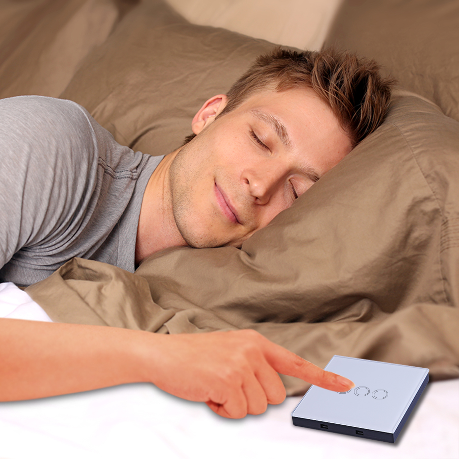 mees lamab voodis ja puudutab puutetundlikku lülitit