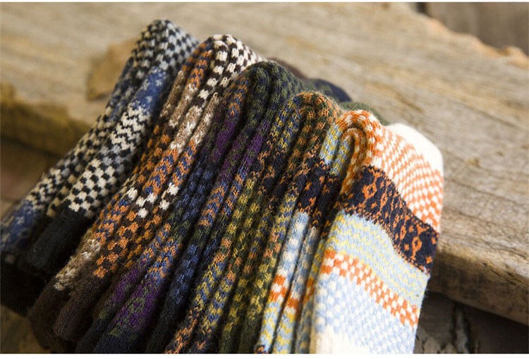 erinevates mustrites ja värvides meeste villased sokid puidust taustal