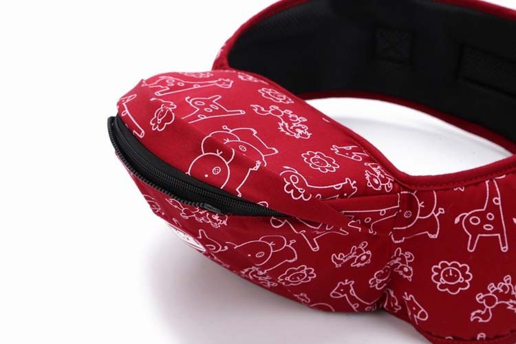 punane kõhukott beebi kandmiseks, millel on valged loomamustrid