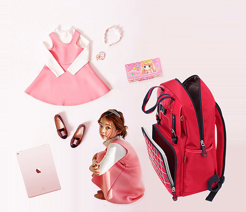 punane koolikott ruudulise mustriga avatud taskuga, kõrval roosa kleit ja aksessuaarid