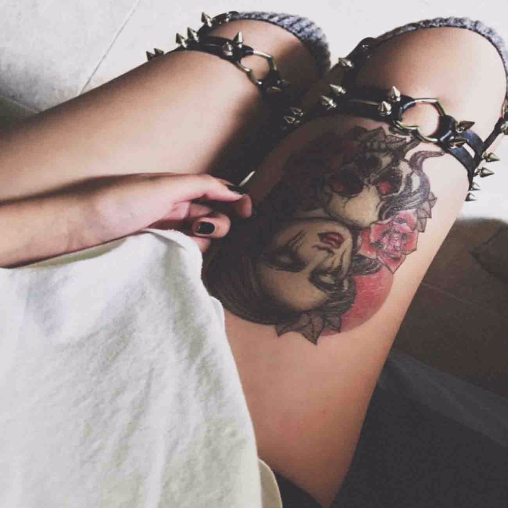 nahast sukahoidja metallist ogadega ja tätoveeringuga reiel