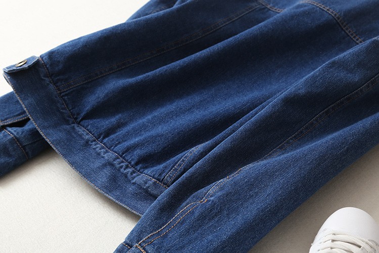 sinine teksatagi, millel on pikad varrukad ja nööbitavad mansetid