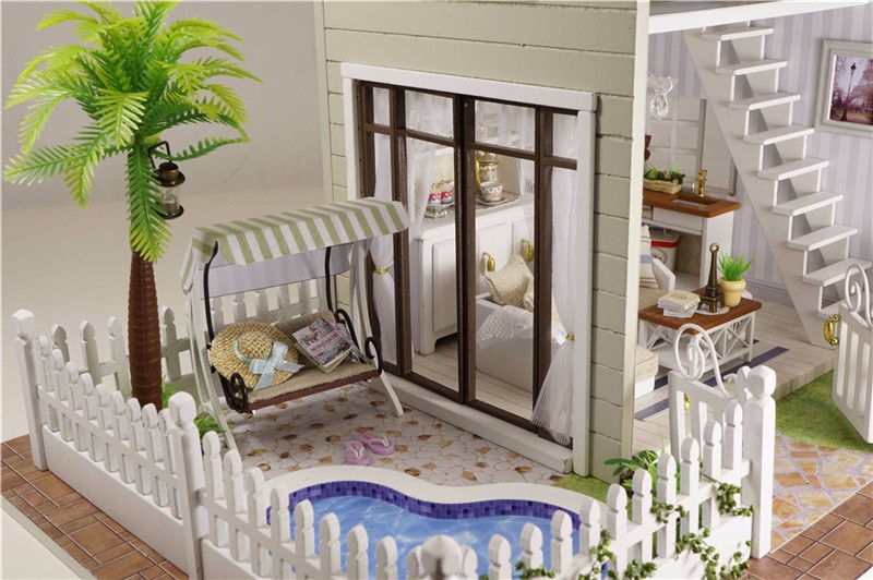 miniatuurne nukumaja, millel on bassein, kiik ja palmipuu