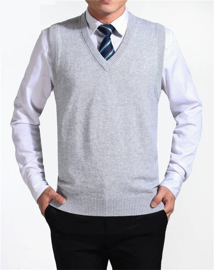 mees kannab heledat halli v-kaelusega vesti valge triiksärgi peal