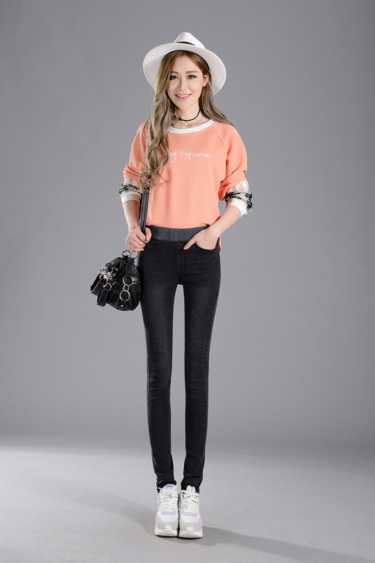 naine kannab musti stretš teksaseid ja virsikuvärvi pusa, peas valge kaabu