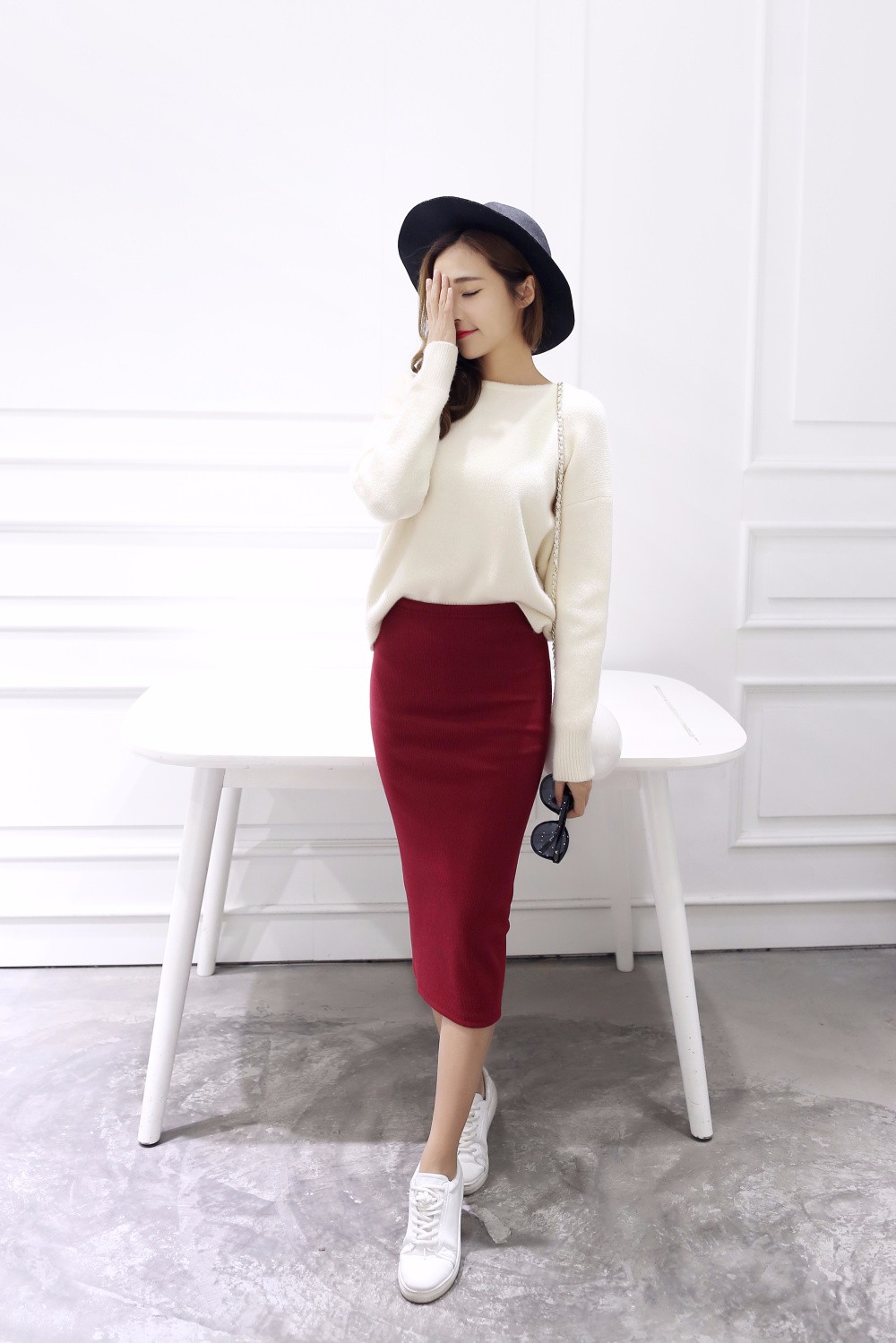 naine kannab punast pliiatsseelikut ja valget kampsunit