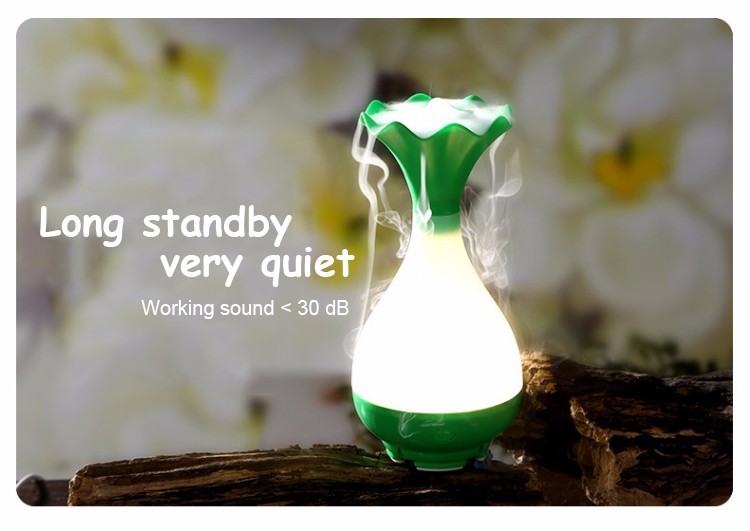 vaasikujuline roheline ja valge õhuniisutaja, mis eraldab auru