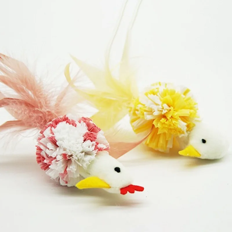 Un par de elementos decorativos que parecen gallinas. Están adornados con plumas y flores, lo que les da un aspecto caprichoso y festivo. Las gallinas son blancas con picos y patas amarillas y tienen detalles rojos en la cabeza y la cola.