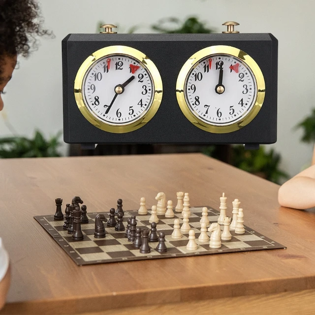 Mão pressionando o relógio de xadrez