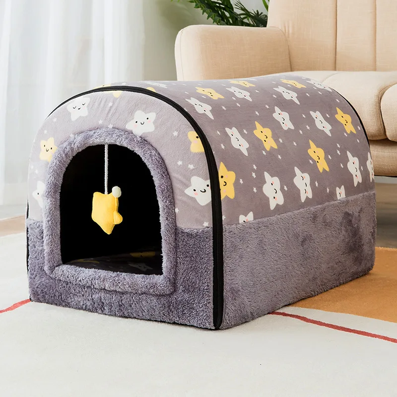 Una cama para mascotas diseñada para gatos. Tiene una apariencia lujosa y acogedora con una combinación de colores gris y blanco y presenta lindas caras de gatos con forma de dibujos animados y estrellas en la tela.