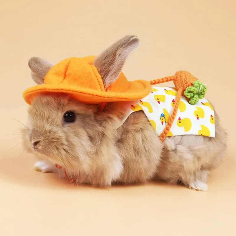 Un conejito pequeño y lindo con gorro y babero. El sombrero es naranja con un pompón verde en la parte superior y el babero tiene un patrón amarillo y blanco con lo que parece ser un diseño de pato.