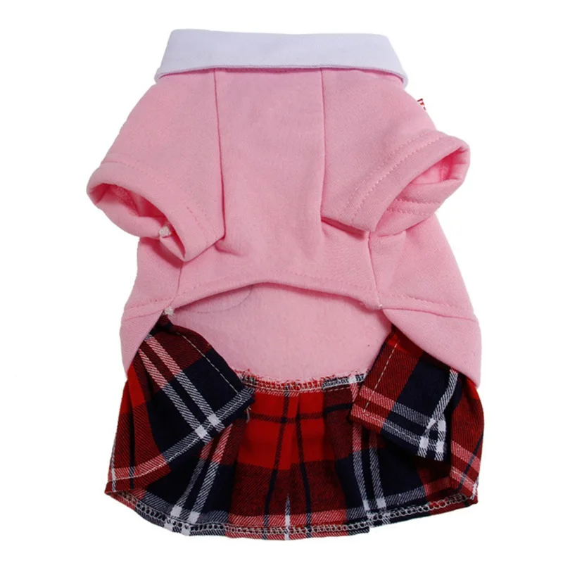 Prenda de vestir que parece ser una falda diseñada para una muñeca o un juguete pequeño. Tiene una capa superior rosa con un ribete blanco y una capa inferior a cuadros rojos y azules. La falda está diseñada para ser usada por una muñeca, como lo indica el tamaño y estilo de la prenda.