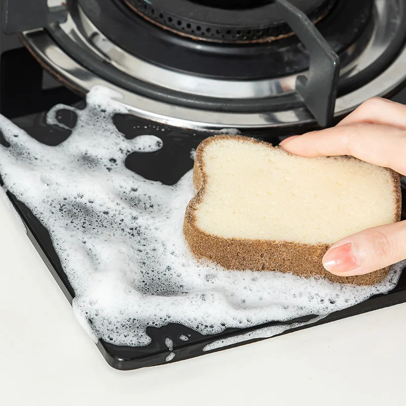 a person cleaning gas stove with a toast shape dish washing sponge in their hand