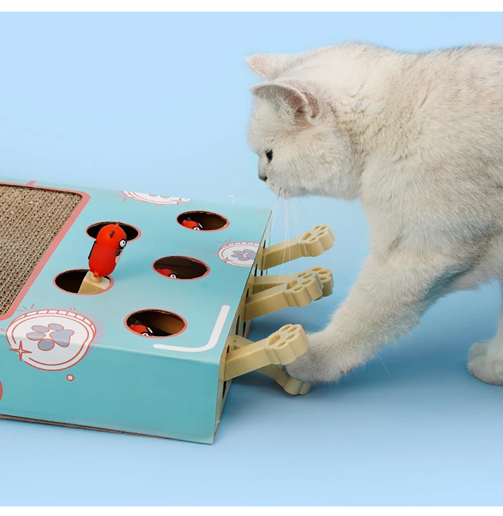 Un gato blanco interactuando con un juguete para gatos. El juguete parece ser una caja con varios agujeros y compartimentos, y hay pequeños objetos rojos y negros que se asemejan a ratones o insectos de juguete. El gato parece estar tocando uno de los juguetes, que sobresale de uno de los agujeros.