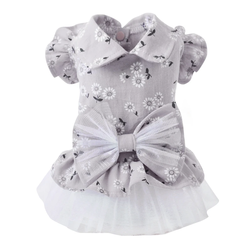 Vestido de bebé con estampado de flores. Presenta un lazo en la parte delantera y parece estar diseñado para un niño pequeño, posiblemente un niño pequeño o un bebé. El vestido tiene mangas cortas y dobladillo con volantes, lo que le da un aspecto lindo y divertido.