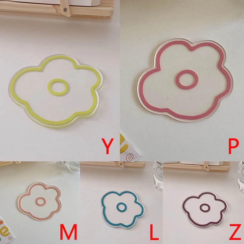 Una colección de cortadores de galletas con forma de flor. Cada cortador tiene un borde de color diferente: amarillo, rosa, azul y morado.