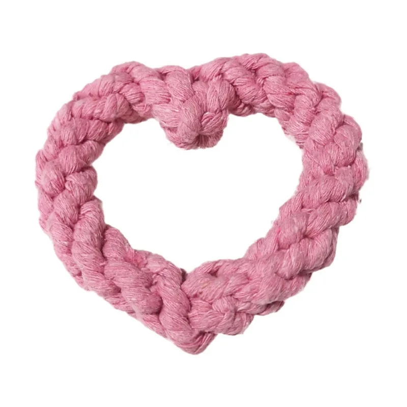 Un objeto tejido o tejido a crochet con forma de corazón. Parece estar hecho de hilo y el color es rosa suave. El corazón está diseñado con una serie de puntadas que le dan una apariencia texturizada.