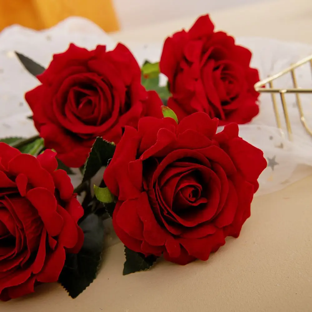 Un ramo de rosas rojas con hojas verdes. Las rosas parecen frescas y están dispuestas de manera que muestren su plena floración.