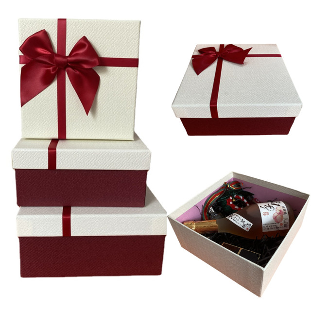 Gift boxes, packing paper, scissors, ribbon on red background