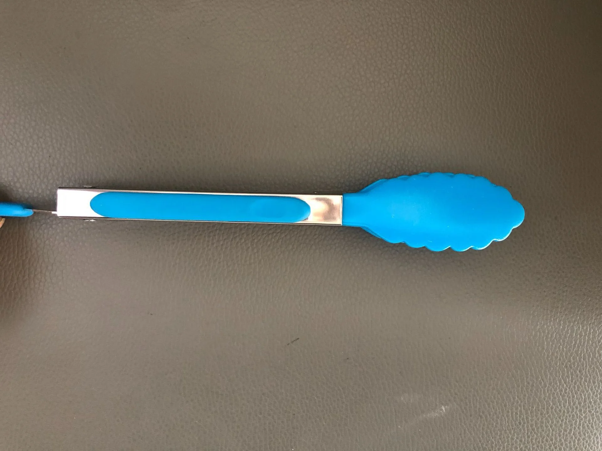 Una cuchara azul y plateada en una superficie negra