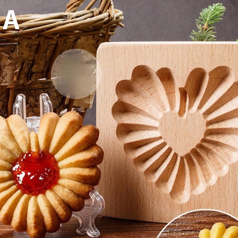 A flower-shaped cookie with a red jam center is displayed next to a beech wood mold from the "Wooden 3D Cookie Cutters, Christmas Biscuit Cutter, Moldes Embossing Mold for Cakes" collection, featuring carved heart patterns. In the background, there is a wicker basket and a small evergreen branch.