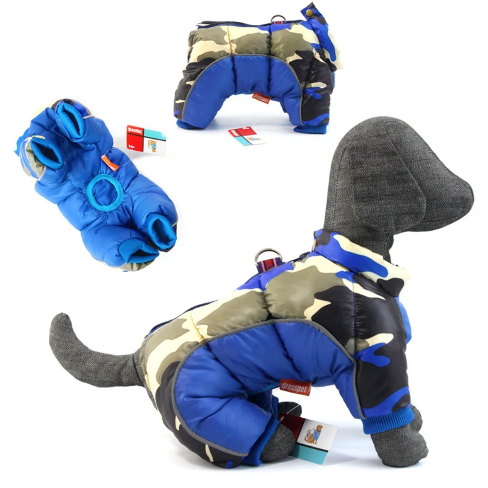 Una colección de artículos que parecen ser ropa o accesorios para mascotas. Hay un perro que lleva un abrigo azul con estampado de camuflaje y capucha, que parece estar diseñado para mantener al perro abrigado.