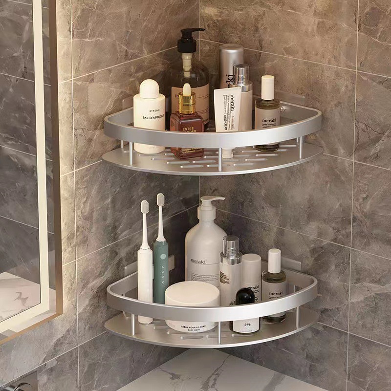 Stainless steel bathroom corner shelf holding lotions and soaps