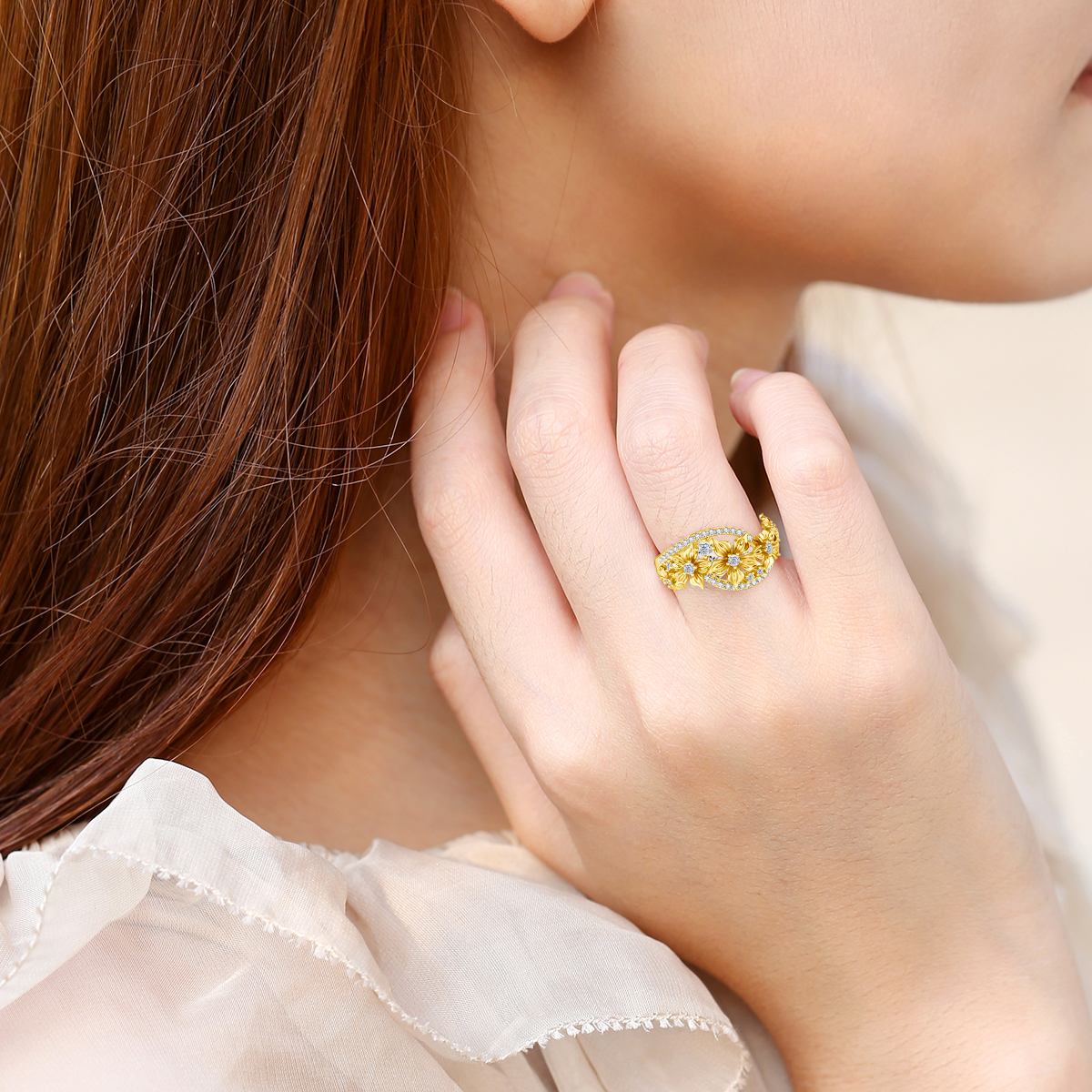 A woman with long brown hair wears a shimmering Moissanite Women Ring, Sterling Silver Jewelry for women, on her finger. Her hand, gently touching her face, complements the light, ruffled blouse she has on. The ring's design ensures it's stylish yet hypoallergenic.