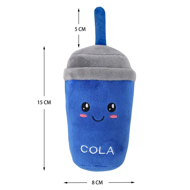 Un peluche diseñado para parecerse a un vaso de refresco. Tiene un cuerpo azul con tapa gris y pajita. El juguete tiene una cara sonriente con ojos y boca, y la palabra COLA está bordada en el frente.