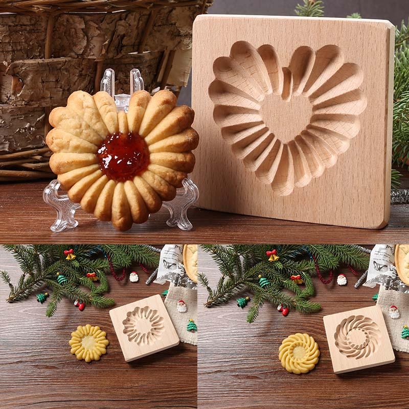 A heart-shaped Wooden 3D Cookie Cutter made from beech wood, creating a freshly baked cookie with a jam center. The image also features an embossing mold with intricately carved floral patterns and a matching cookie, displayed on a rustic wooden table decorated festively.