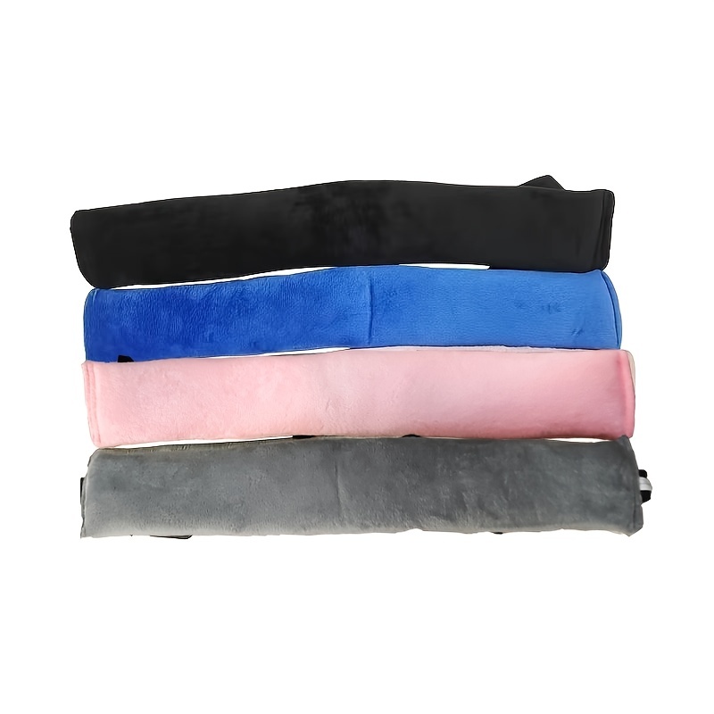 A set of four plush seat belt covers in black, blue, pink, and gray are arranged horizontally. Each soft and fuzzy cover is crafted to offer comfort and style, reminiscent of the snug feel provided by the High Chair Security Straps designed for infants and toddlers.