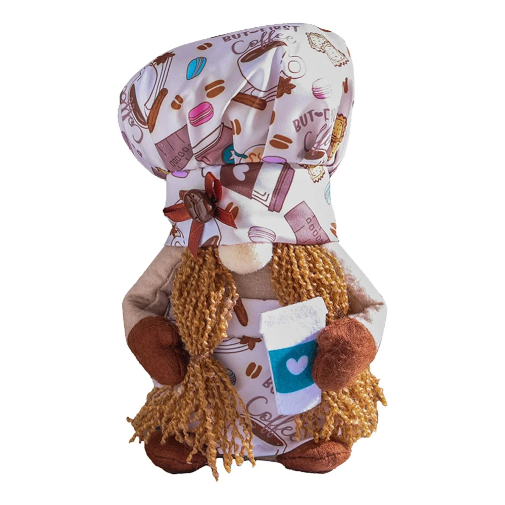 Un peluche diseñado para parecerse a un chef o un panadero. Tiene un gorro de chef con un estampado de temática cafetera y el cuerpo está adornado con una bufanda que también tiene un diseño de temática cafetera.