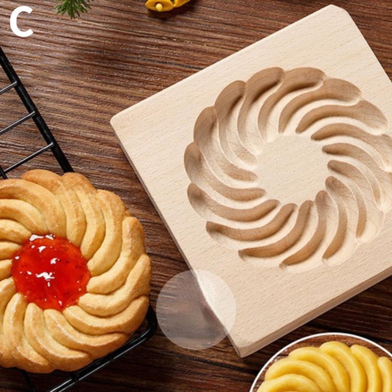 Using the Wooden 3D Cookie Cutters, Christmas Biscuit Cutter, and Moldes Embossing Mold for Cakes, a beech wood cookie mold with a spiral design creates delightful treats. The resulting baked cookie, graced with red jam, is perfectly shaped and placed on a wooden surface next to a cooling rack.