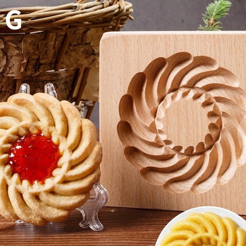 A decorative cookie with a red center is displayed on a stand alongside the Wooden 3D Cookie Cutters, featuring matching intricately carved patterns. In the background, there is a woven basket.