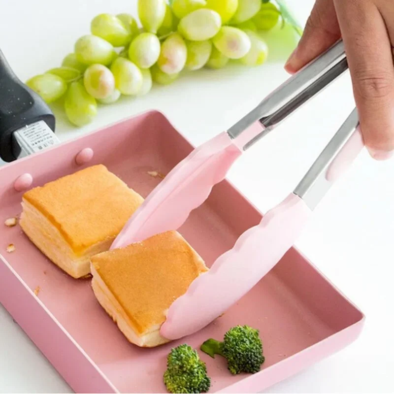 Una persona está cortando un trozo de pan con un cuchillo de plástico rosa.